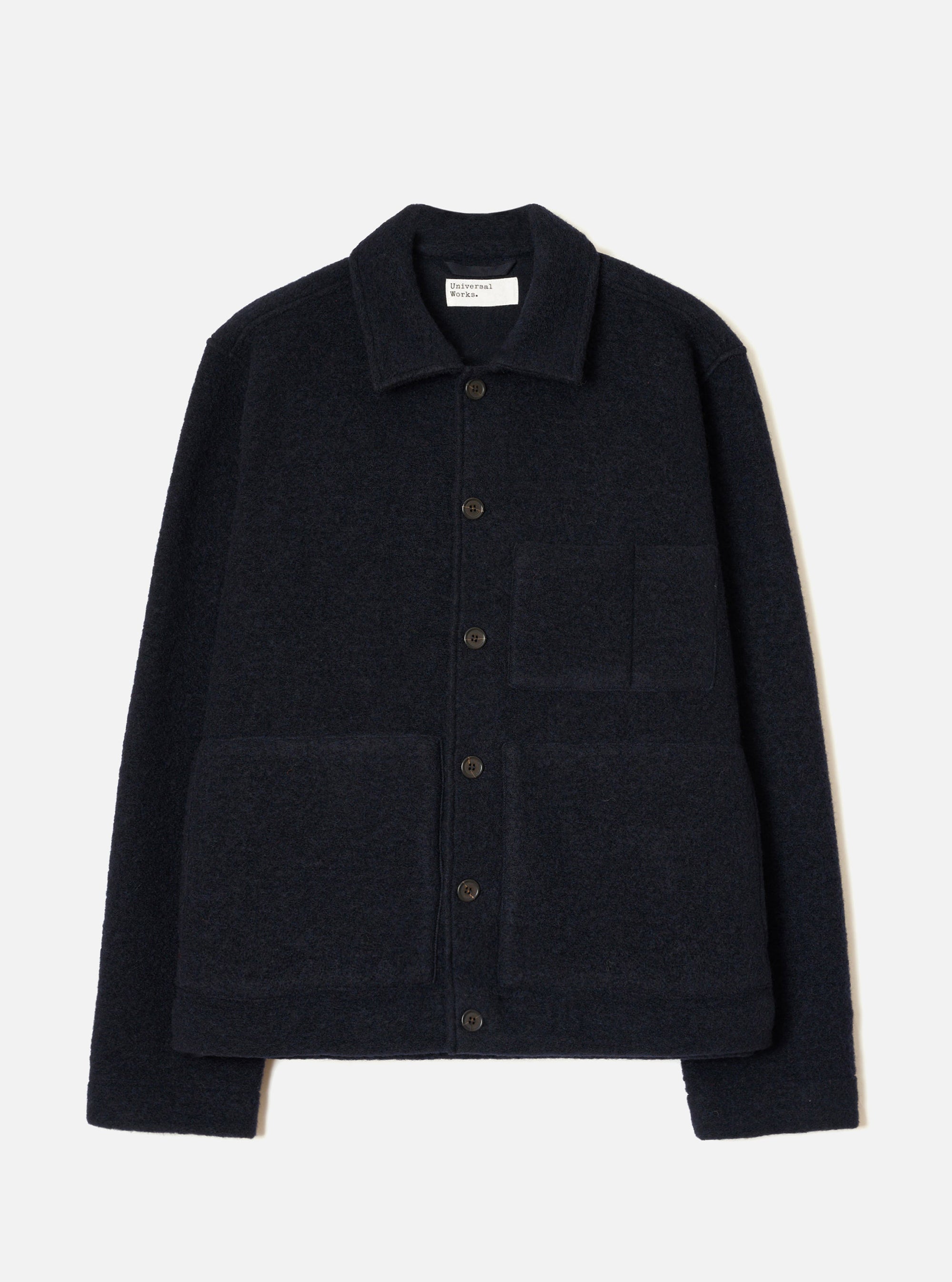 Navy wool fleece uniform jacket laid flat on a light grey seamless backdrop. Features a spread collar, five dark horn buttons down the centre front, two large patch pockets on the chest and lower front, and a ribbed hem and cuffs. The textured fleece has a dense, looped surface throughout.