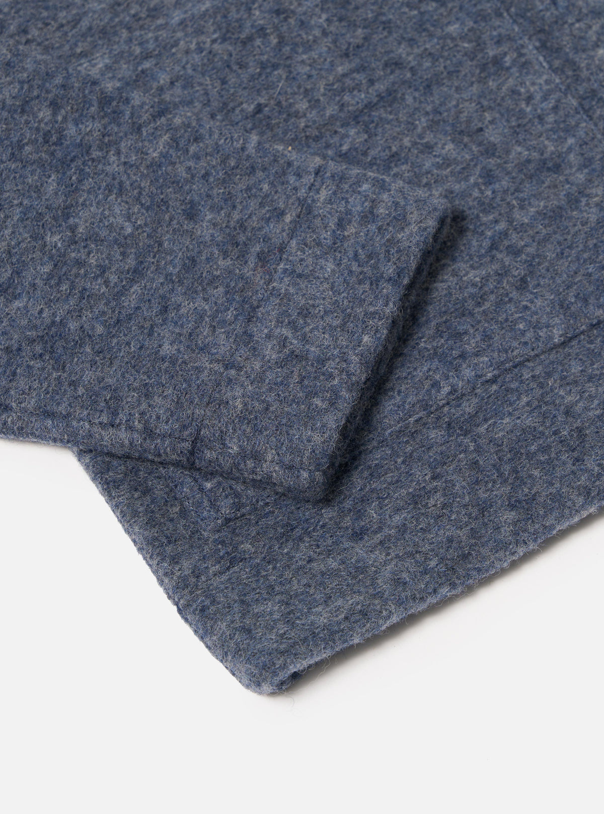 Close-up of the Slate Blue Wool Fleece Uniform Jacket sleeve on a white background, showcasing the material's texture.