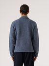 Back view of a model wearing a Slate Blue Wool Fleece Uniform Jacket. The jacket is on a white background and paired with dark pants.