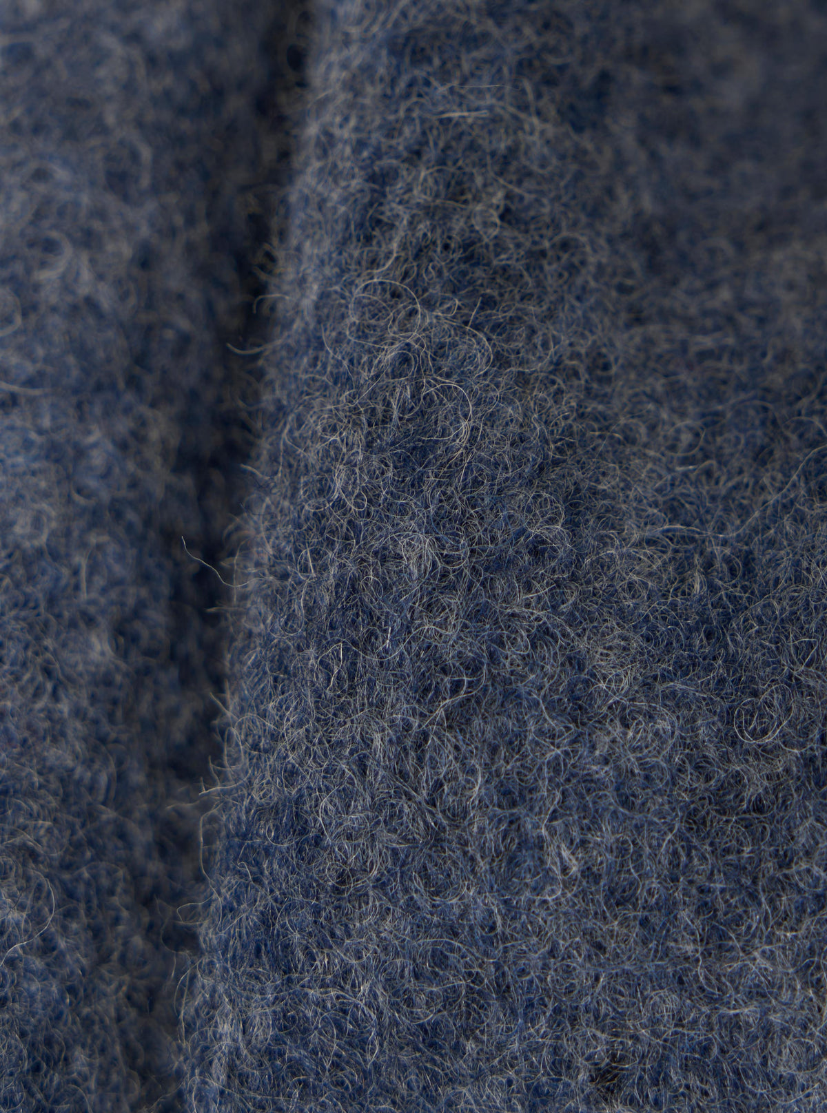 Close-up of the Slate Blue Wool Fleece Uniform Jacket, showing the texture and color of the wool fleece material. The background is a plain surface.