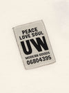 Close up of the label on the Ecru Single Jersey Core Tee. The label is gray with black text. The tee is ecru.