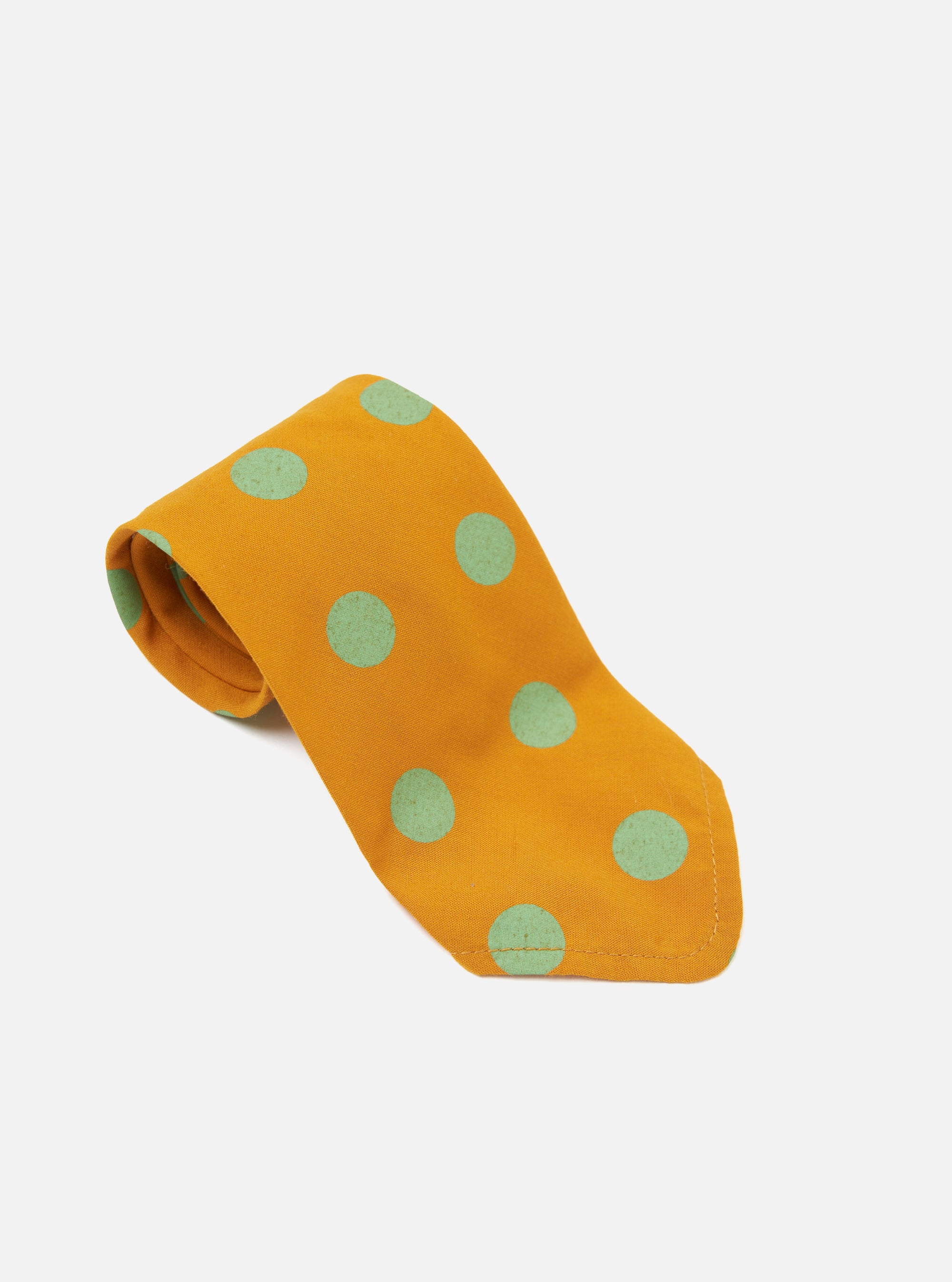 The Mustard Bold Dot Print Rayon Tie is displayed on a white background. The tie is mustard yellow with large, bold, light green dots. The tie is made of rayon.