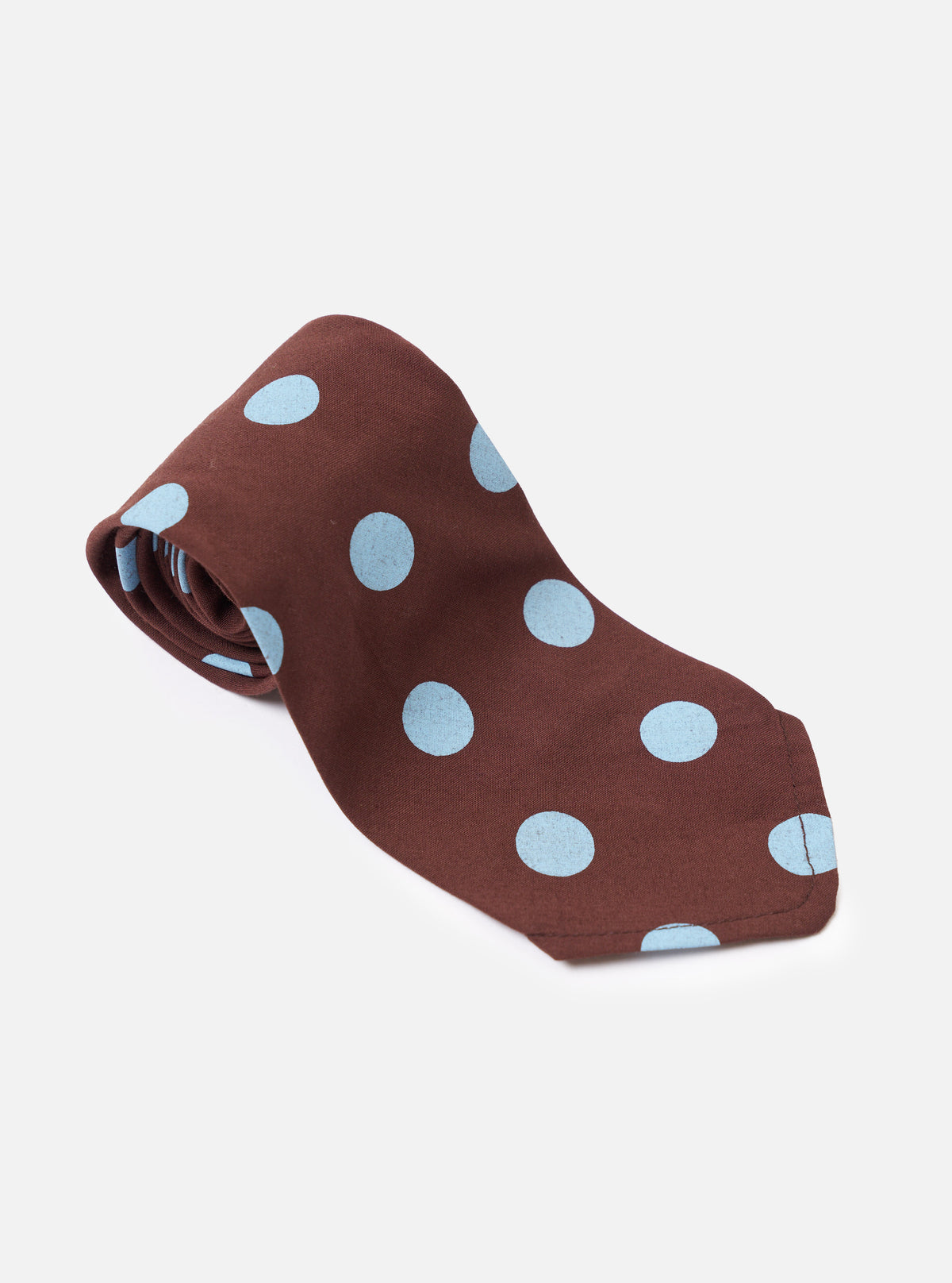 The Brown Bold Dot Print Rayon Tie is shown from the back as a flat lay against a plain white background. The image highlights the construction of the tie, including the keeper loop and the finished tip. The brown rayon fabric features a prominent white bold dot print throughout.