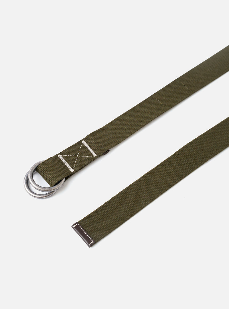 The Olive Canvas Webbing O Ring Belt is displayed as a flat lay against a plain white background. The belt features a textured olive green canvas webbing construction with visible contrast stitching and a double metal O-ring buckle for an adjustable closure.