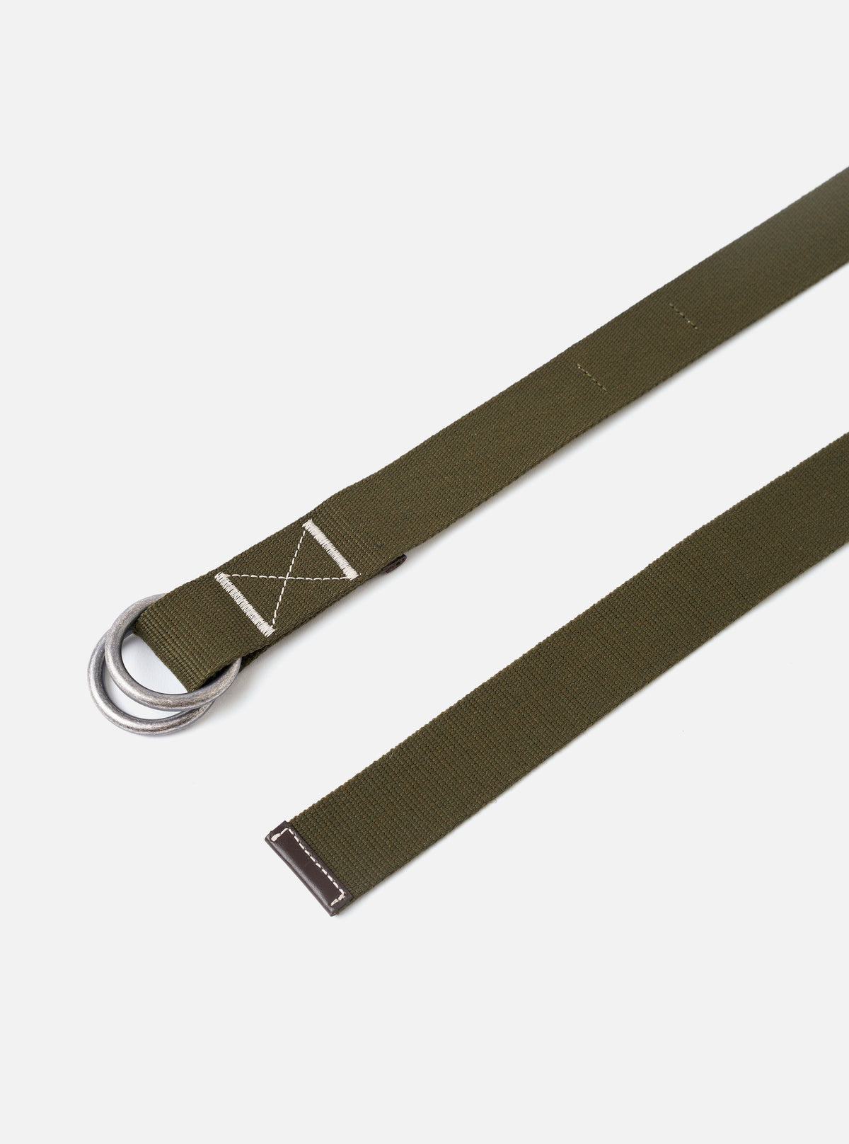 The Olive Canvas Webbing O Ring Belt is displayed as a flat lay against a plain white background. The belt features a textured olive green canvas webbing construction with visible contrast stitching and a double metal O-ring buckle for an adjustable closure.