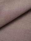Close-up of the brown chambray fabric used in the Daybrook Shirt. The plain-weave textile shows a fine two-tone woven texture with subtle natural slubs across the surface. The fabric is folded diagonally, revealing depth and drape. No garment construction details are visible.