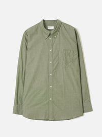 Olive chambray long-sleeve shirt laid flat on a light grey background. Button-down collar with collar buttons visible, full button placket with five cream buttons, single chest patch pocket on the left, buttoned cuffs, and a curved hem. Fine woven texture throughout. Universal Works woven label at the neck.