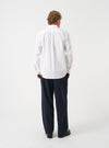 Three-quarter angle view of a model wearing the White Prince Chambray Daybrook Shirt against a plain backdrop. The shot shows how the shirt fits across the shoulders and torso, highlighting the light cotton chambray material.