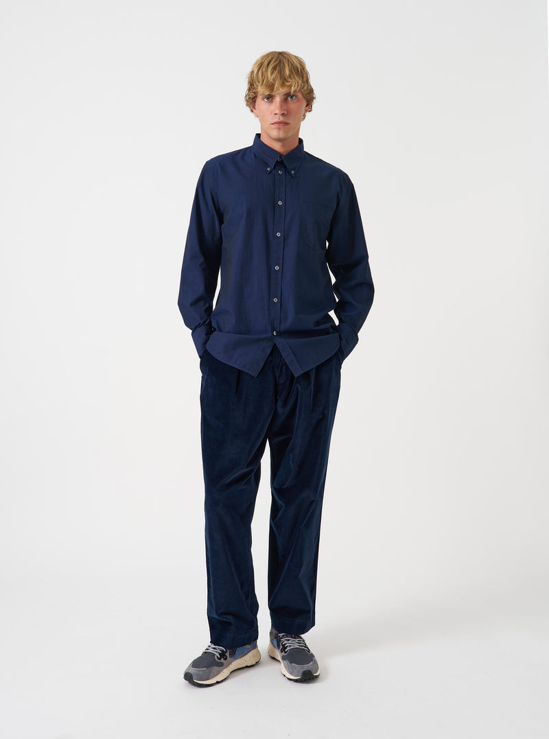 Front view of a model wearing the Navy Prince Chambray Daybrook Shirt in a plain studio setting. The model faces forward, highlighting the classic collar, chest pocket, button placket, and navy blue chambray texture.