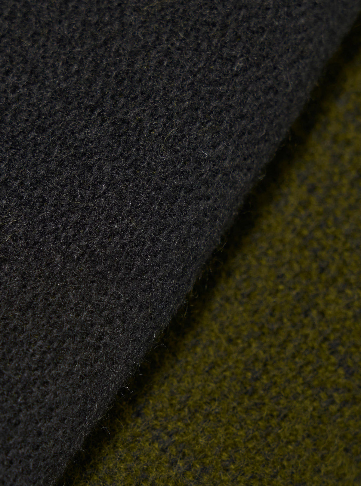 Close-up fabric swatch image showcasing the material of the Green/Black Double Sided Scarf. The detailed shot highlights the rich green and black tones, soft knit texture, and double-sided woven construction of the accessory.