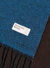 Draped view of the Light Blue/Brown Double Sided Scarf shown against a clean studio backdrop. The photo highlights how the light blue and brown fabric layers fold together, emphasizing the soft texture and subtle fringed trim.