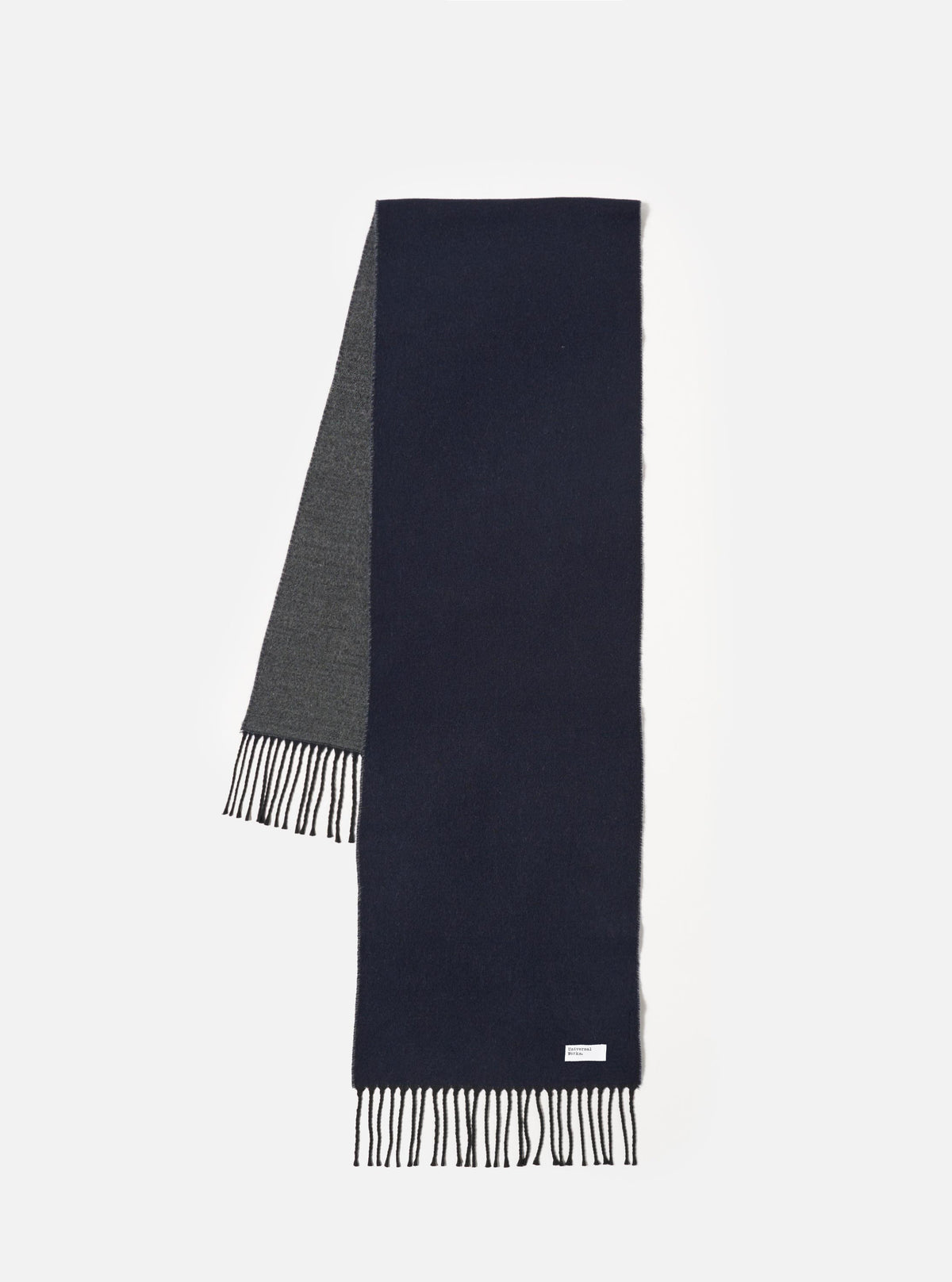 Front view of the Navy/Mid Grey Double Sided Scarf displayed flat on a plain white background. The image highlights the reversible design with navy blue on one face and mid-grey on the opposite side, along with fringed ends.