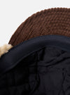 Close-up of the inside of a cableami® Brown Corduroy 5w Cap showing the quilted black lining and brown corduroy material against a white background.