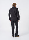 Side angled view of a male model wearing the Black Twill London Jacket in a studio setting with a clean neutral background, displaying the silhouette, sleeve length, and jacket drape when worn.