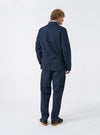 Three-quarter view of a male model wearing the Navy Twill London Jacket in a bright studio environment, demonstrating the jacket drape, arm length, and deep navy blue color against a plain backdrop.