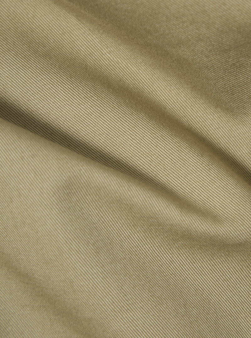 Close-up of the sand twill fabric of the London Jacket, showing the texture and color. The material is draped to highlight its quality.