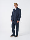 Front view of a model wearing the Navy Twill Bakers Chore Jacket layered over a shirt in a light studio setting. The model stands facing forward, showing the relaxed fit and pocket layout of the navy jacket.