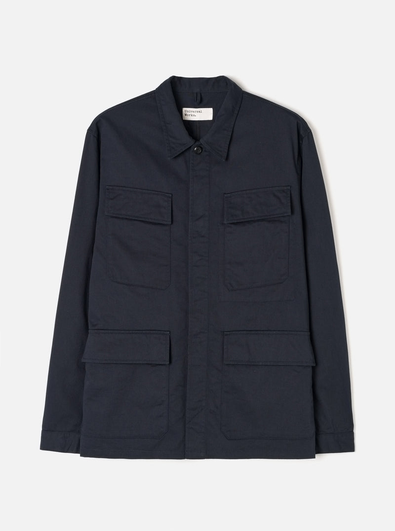 Front view of the Navy Twill MW Fatigue Jacket displayed against a white background. Shows four front flap pockets, hidden button placket, folded collar, and structured military-inspired utility style in navy.