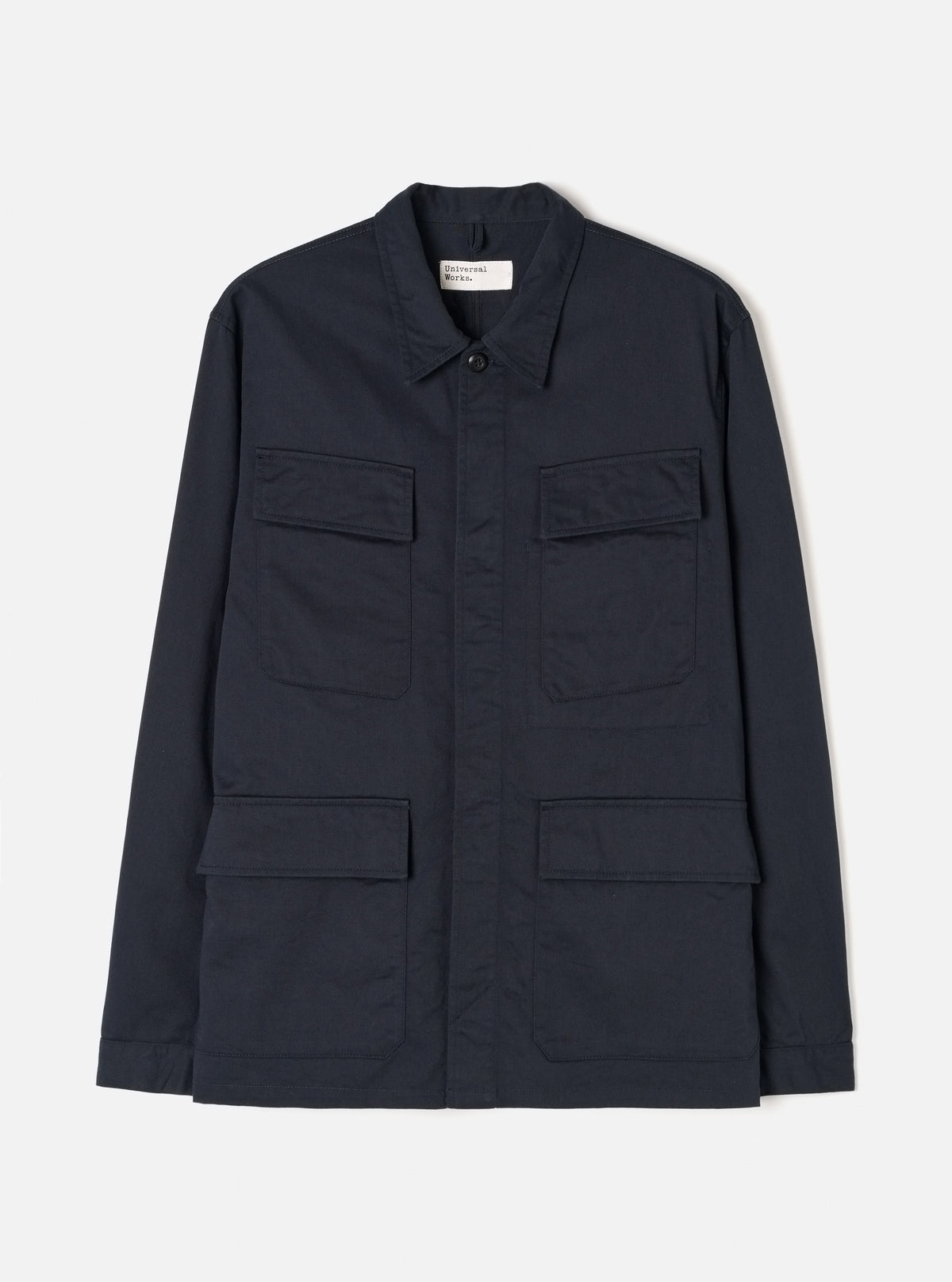 Front view of the Navy Twill MW Fatigue Jacket displayed against a white background. Shows four front flap pockets, hidden button placket, folded collar, and structured military-inspired utility style in navy.
