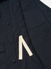 Close-up detail shot of the front flap pocket and hidden button closure on the Navy Twill MW Fatigue Jacket. Displays the dark navy cotton twill weave, neat topstitching, and pocket flap design.