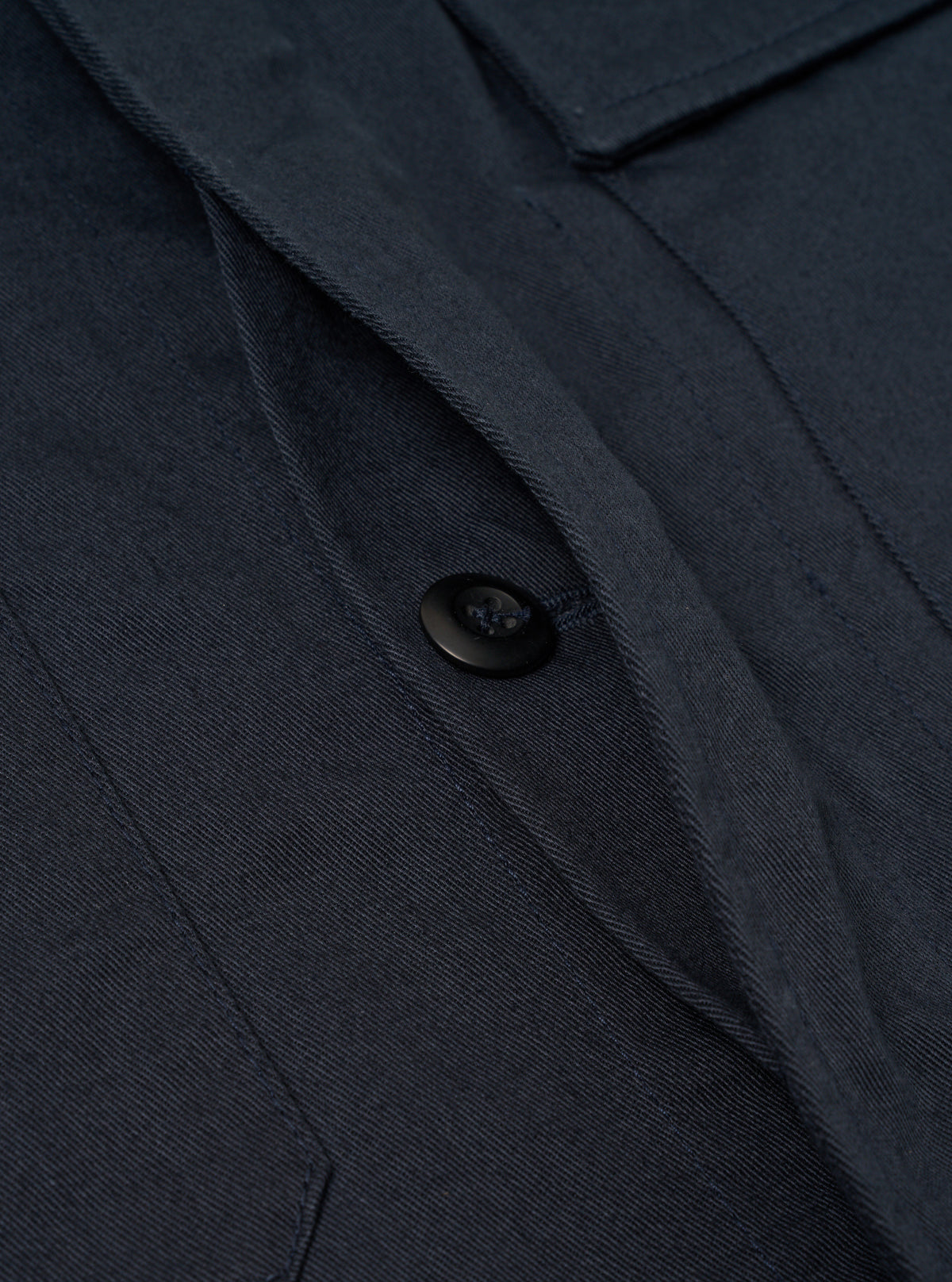 Detailed close-up shot of the collar area and upper placket on the Navy Twill MW Fatigue Jacket against a white background. Focuses on the top button, visible neck tab, and collar construction.