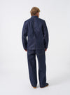 Back view of the Indigo 13oz Selvedge Denim Trucker Jacket on a plain background. The shot highlights the clean rear paneling, tailored shoulder seams, dark blue denim finish, and adjustable waist tabs located near the bottom hem.