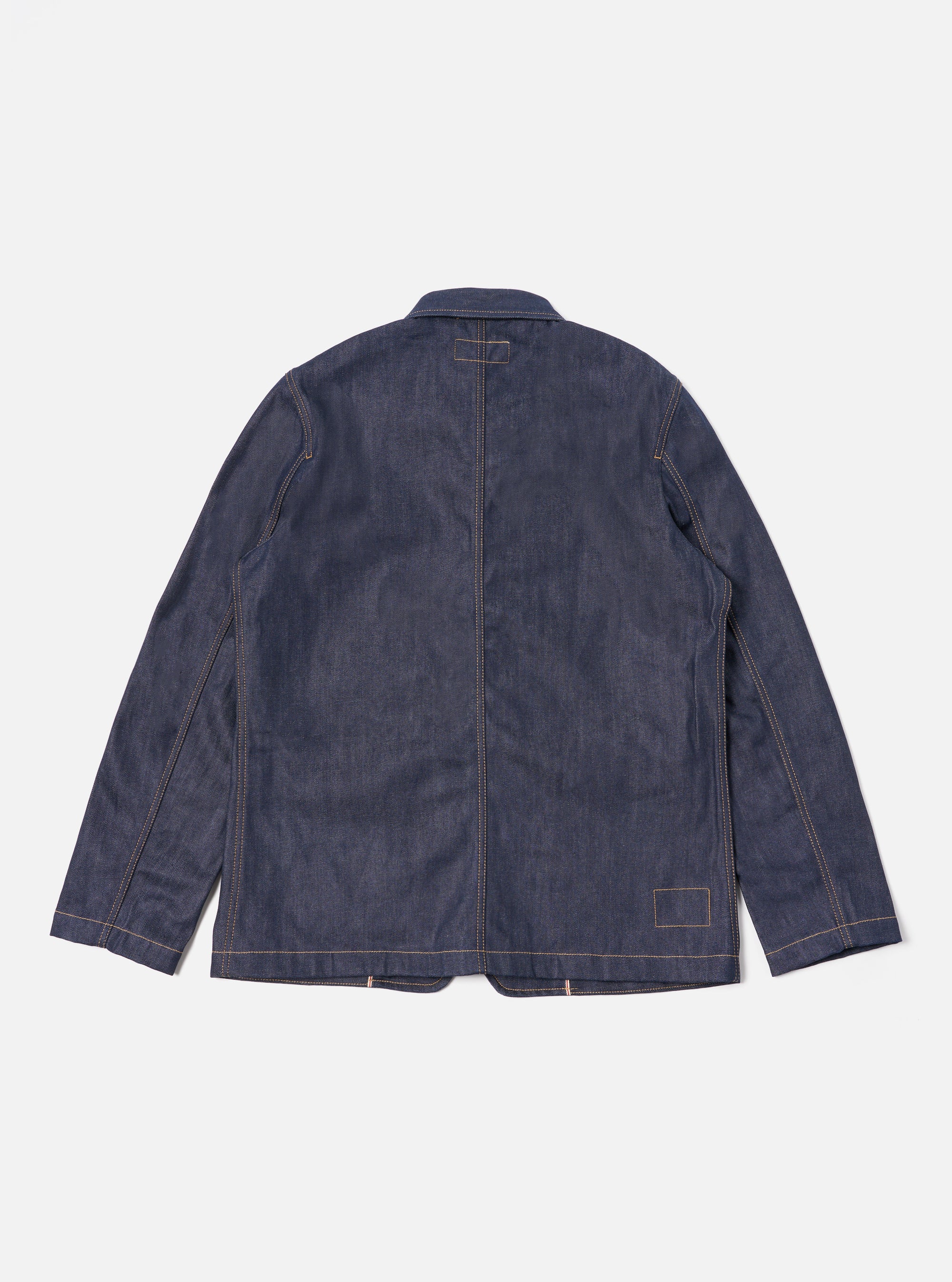 Back view of the Indigo 13oz Selvedge Denim Bakers Jacket on a white background. The jacket is dark blue denim with tan stitching. 
