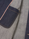 Close-up detail view of the Indigo 13oz Selvedge Denim Bakers Chore Jacket on a neutral background, highlighting the contrast stitching, front button placket, collar, and chest pocket detail.