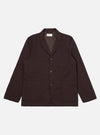 A Brown Twill Three Button Jacket is displayed laid flat against a plain white background. The jacket features a three-button front closure, a notched lapel, and three patch pockets on the front.