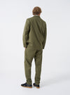 A model wearing the Light Olive Twill Three Button Jacket shown from a side perspective against a plain studio backdrop, demonstrating how the garment fits around the shoulders and body.