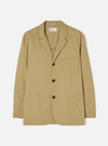 Front view of the Sand Twill Three Button Jacket set against a plain white studio background, showcasing its warm beige tone, three-button closure, lapels, and patch pockets.