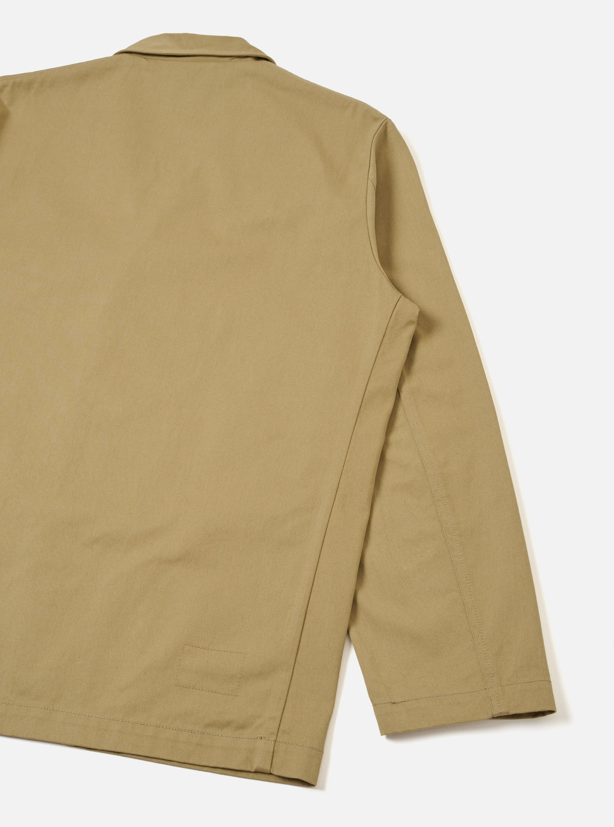 Back view of the Sand Twill Three Button Jacket displayed on a white background, highlighting the rear tailoring, center vent seam, smooth shoulders, and crisp sand-colored twill fabric.