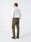 Rear shot of a model wearing the Light Olive Twill Military Chino against a white background. Shows the back fit of the light olive cotton trousers, highlighting the rear buttoned flapless pockets and tapered fit down to the ankles.