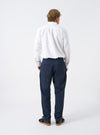 Back view of a model wearing the Navy Twill Military Chino against a white background. Demonstrates the fit around the waist and seat, showing the rear jetted button pockets and straight-to-tapered cut on the navy cotton trousers.