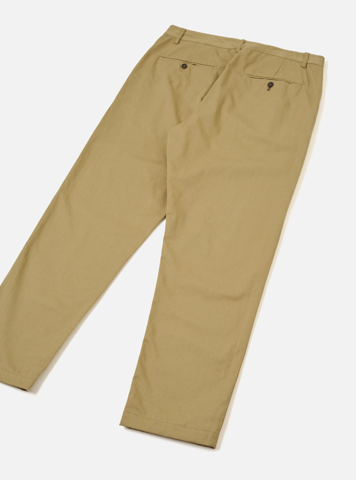 Back view of the Sand Twill Military Chino laid flat against a clean white backdrop. Features two jetted rear pockets with button closures, central seam details, and a gradual taper down to the hem in light sand cotton twill fabric.