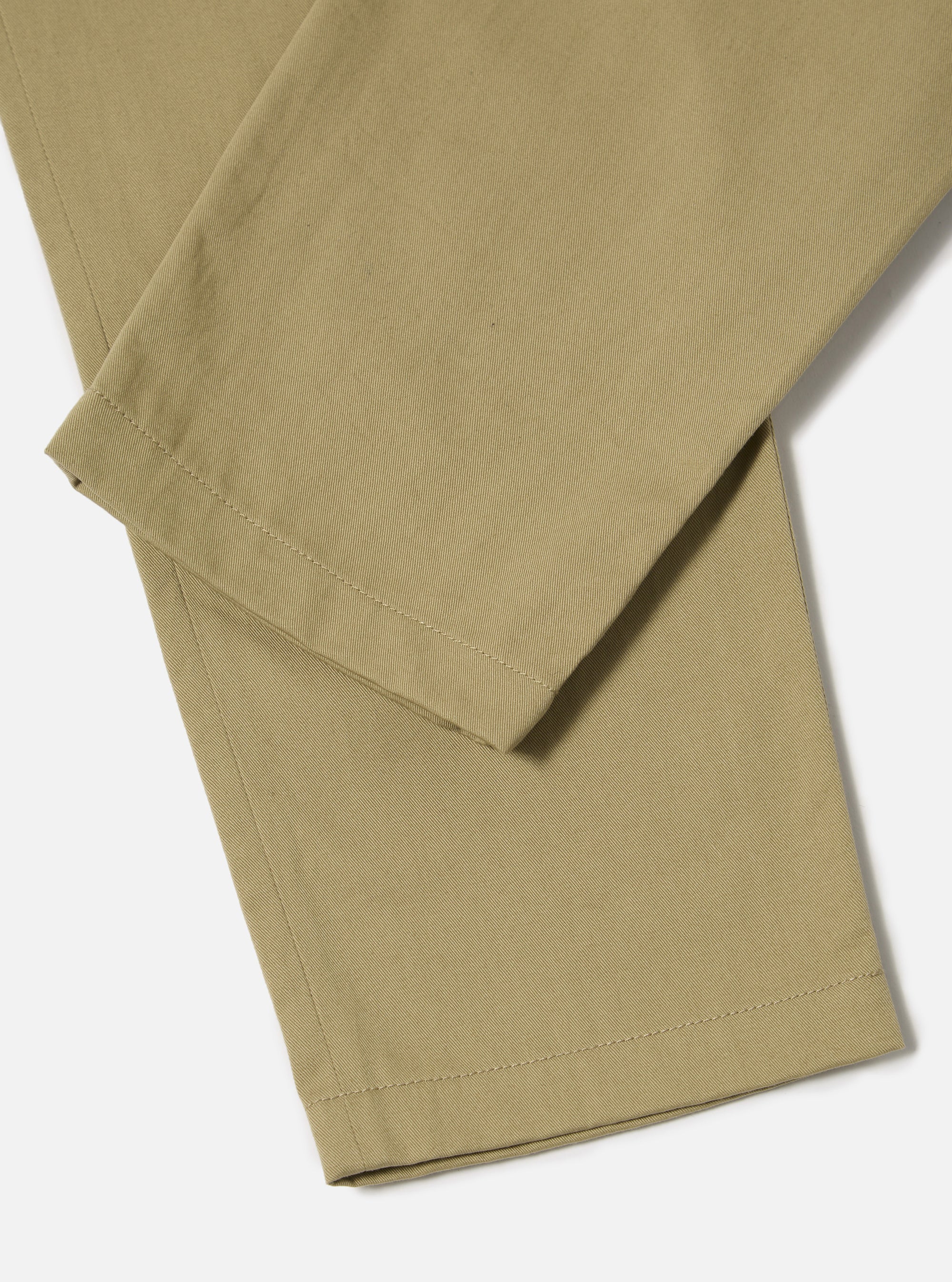 Close-up of the Sand Twill Curved Pant on a white background. The sand-colored twill fabric shows a subtle texture and clean lines.