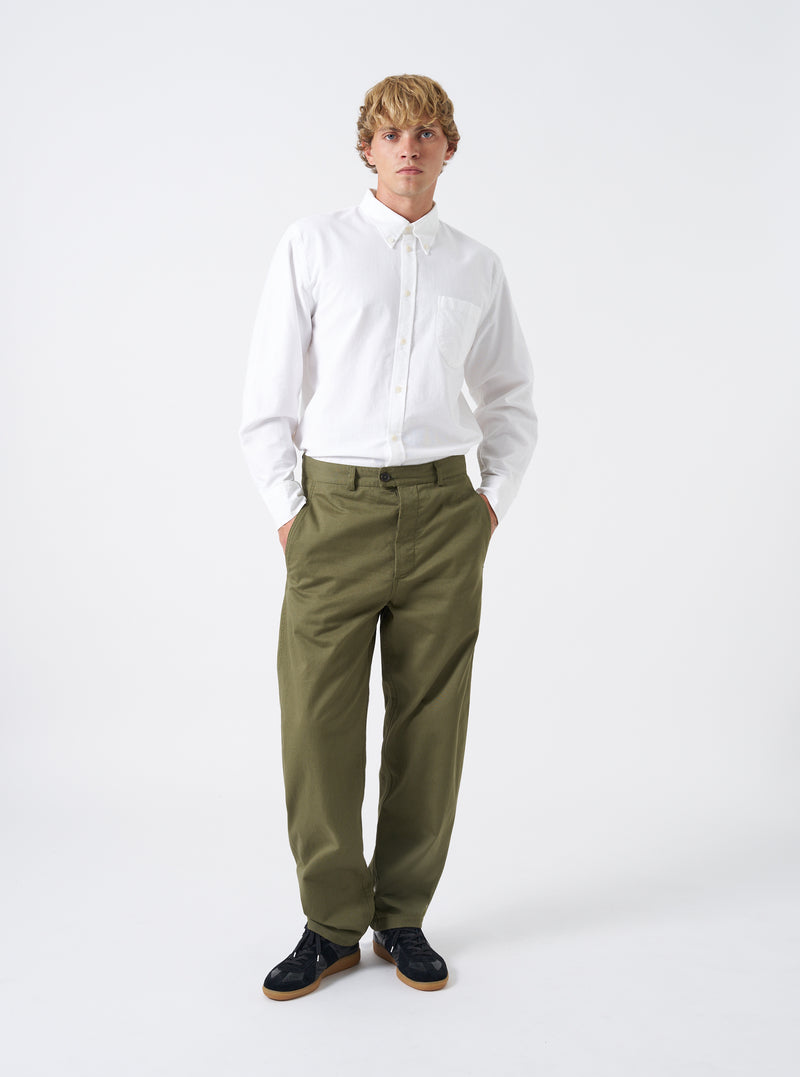 Front view of a model wearing the Light Olive Twill Curved Pant set against a neutral studio background. The model wears the olive trousers with footwear, illustrating the comfortable relaxed fit and curved side seams.