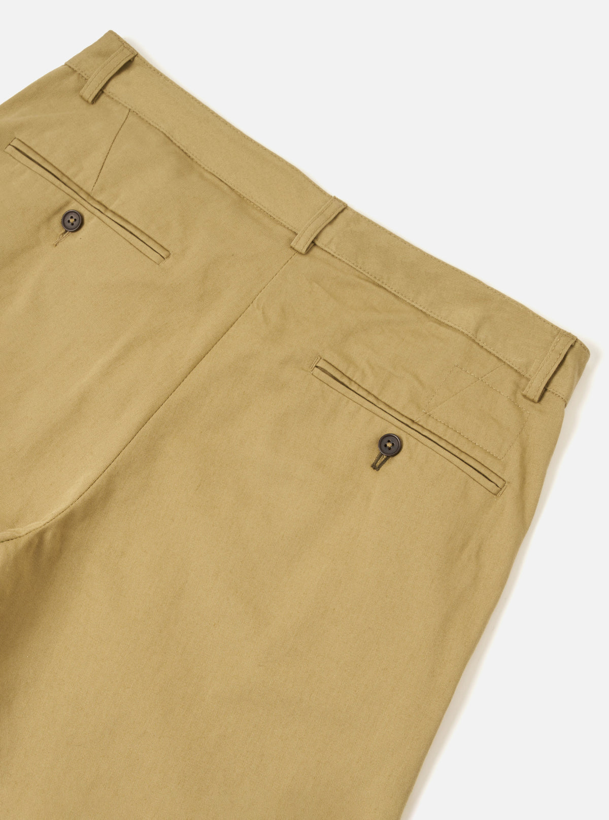 Detailed close-up shot of the front waist section of the Sand Twill Aston Pant on a white background. Emphasizes the zip fly closure, sturdy waistband stitching, front pocket entry, and natural tan twill cotton weave texture.