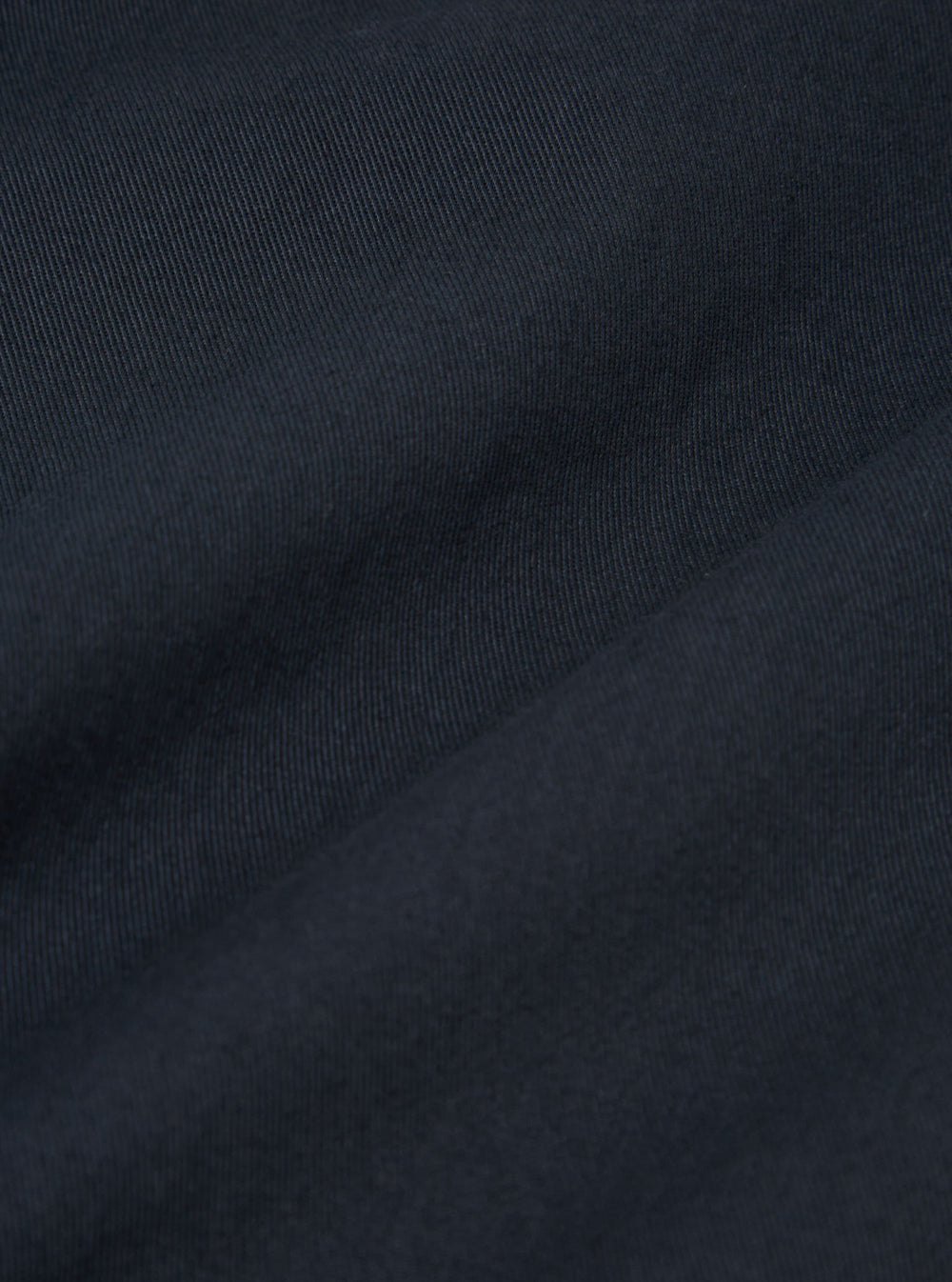The Navy Twill Franck Jacket is shown from the back as a flat lay against a plain white background. The image highlights the jacket's simple, straight-cut rear construction and the durable texture of the navy blue cotton twill fabric.