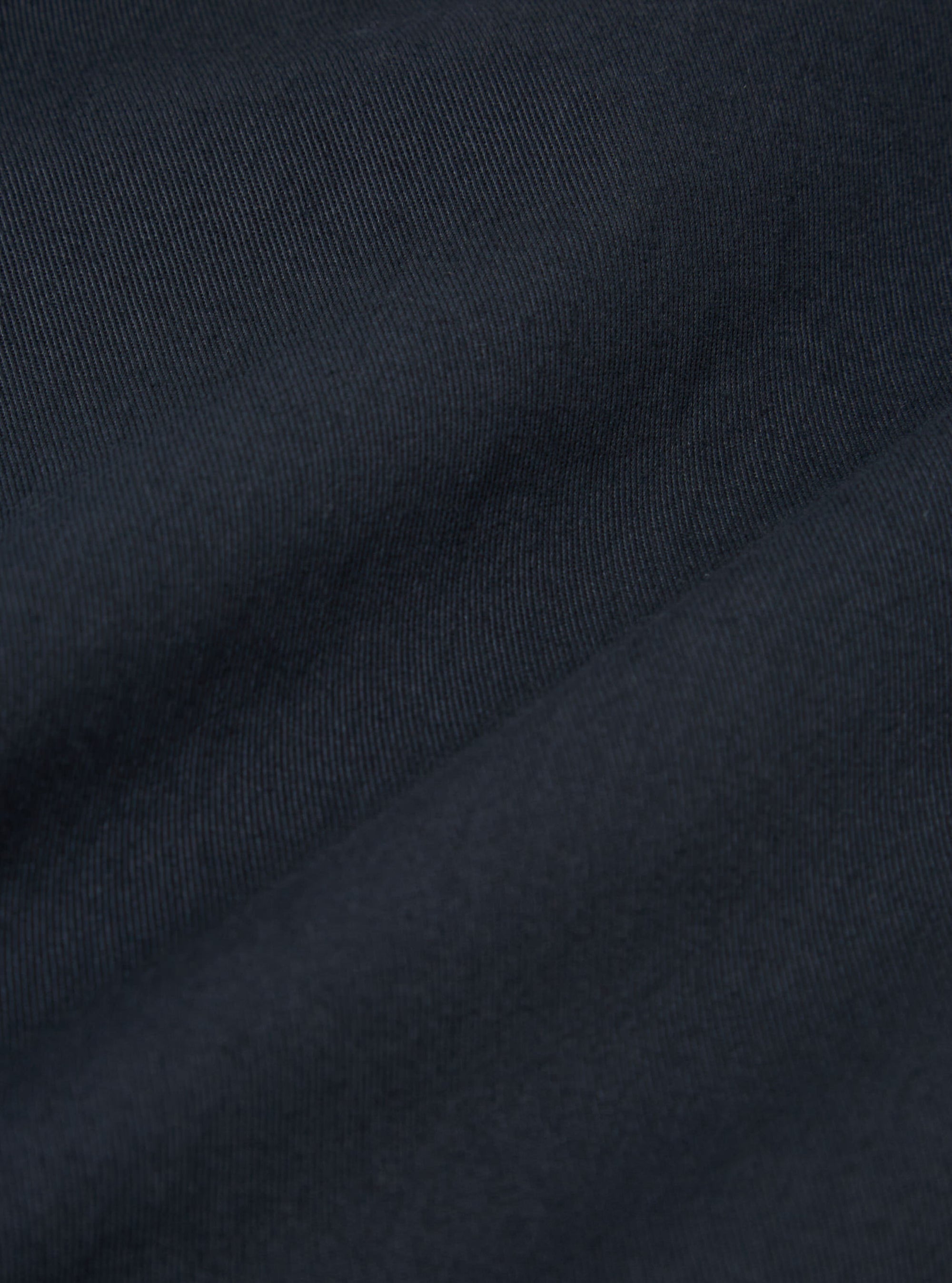 The Navy Twill Franck Jacket is shown from the back as a flat lay against a plain white background. The image highlights the jacket's simple, straight-cut rear construction and the durable texture of the navy blue cotton twill fabric.