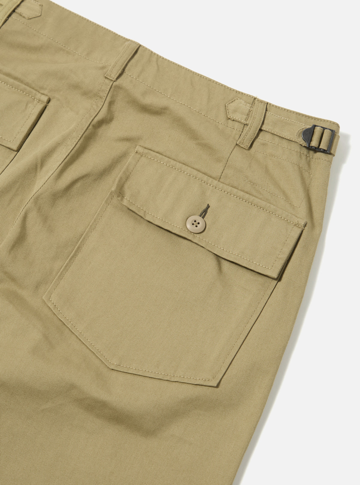Close-up of the back of the Sand Twill Fatigue Pant on a white background. The twill fabric is a light tan color. Features a buttoned pocket and adjustable belt.