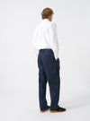 Side perspective of a model wearing the Navy Twill Double Pleat Pant against a plain background. Illustrates the wide leg shape, front pleat depth, and tailored waist fit when worn on the body.
