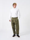 Full-length shot of a model wearing the Light Olive Twill Pleated Track Pant against a neutral background. Shows the relaxed tapered leg fit, drawstring waist, and soft drape of the twill fabric.