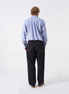 Additional shot of a model wearing the Black Twill Pleated Track Pant on a neutral background. Highlights the movement and drape of the pleated black twill fabric along with the casual tapered fit.