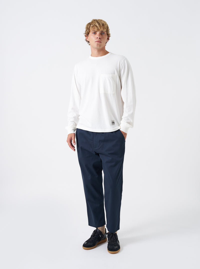 A model wears the Navy Twill Hi Water Trouser against a bright white background. The full-length front view highlights the loose relaxed fit, drawcord waist, dark navy twill texture, and cropped leg opening sitting above the ankle.