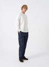Front shot of the Indigo 13oz Selvedge Denim Military Chino against a plain white background. Displays the mid-rise waist, classic button fly, side slash pockets, rich dark indigo wash, and contemporary tapered leg silhouette.