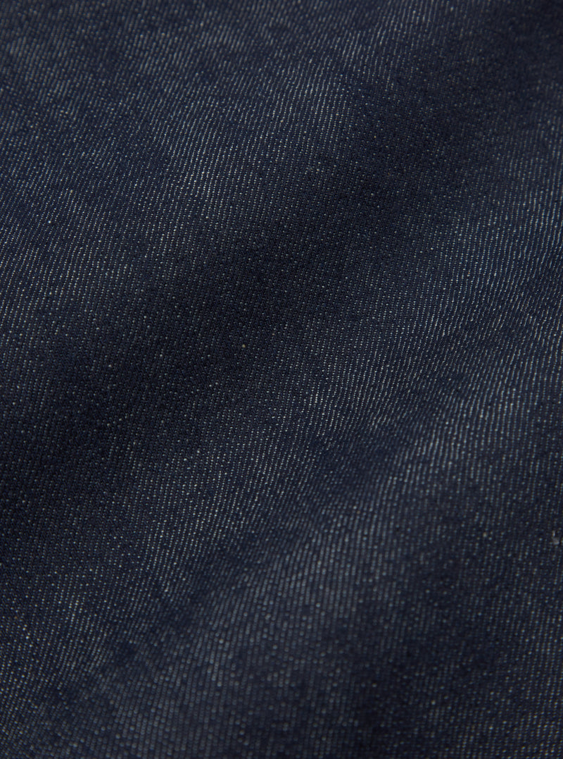 Rear view of the Indigo 13oz Selvedge Denim Duke Pant - Longer Length styled on a model against a clean, light studio background. The image focuses on the back pockets, dark indigo wash, extended hemline, and relaxed leg silhouette.