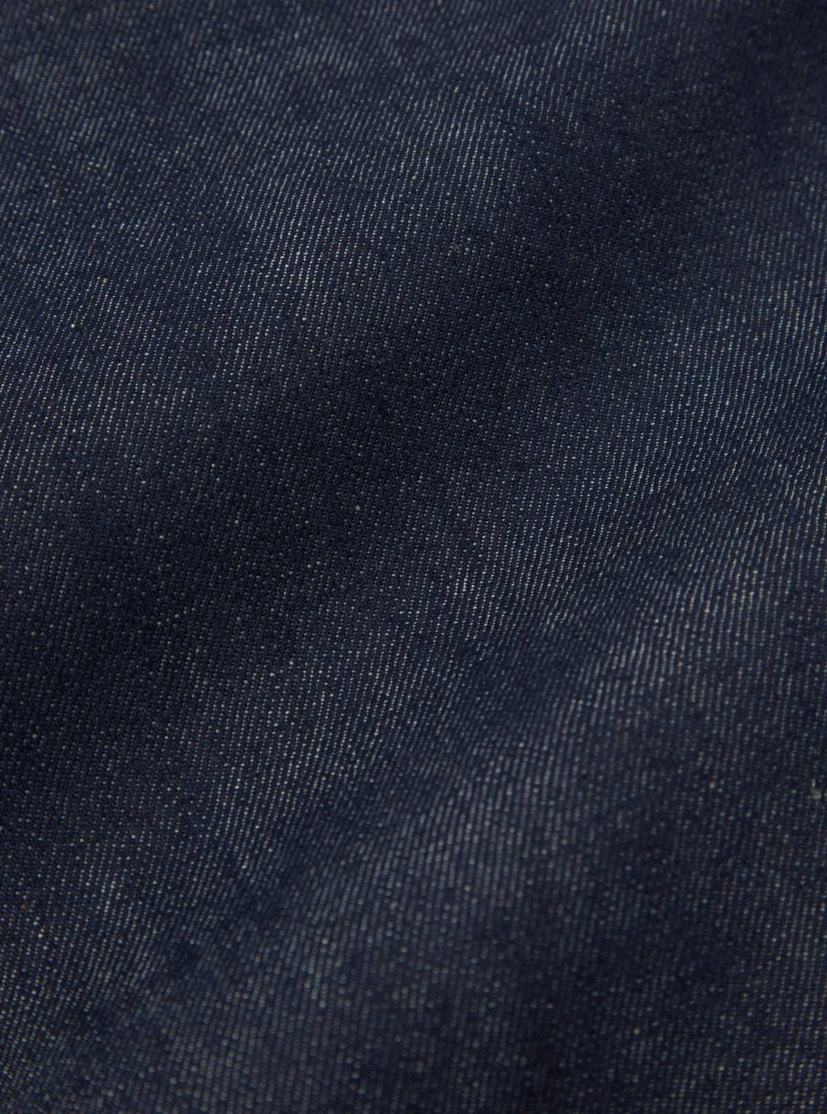 Rear view of the Indigo 13oz Selvedge Denim Duke Pant - Longer Length styled on a model against a clean, light studio background. The image focuses on the back pockets, dark indigo wash, extended hemline, and relaxed leg silhouette.