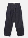 Full-length front shot of a male model wearing the Indigo 13oz Selvedge Denim Duke Pant - Longer Length against a plain off-white background. The image displays the loose, wide fit, double pleats, dark blue denim, and turned-up hems.
