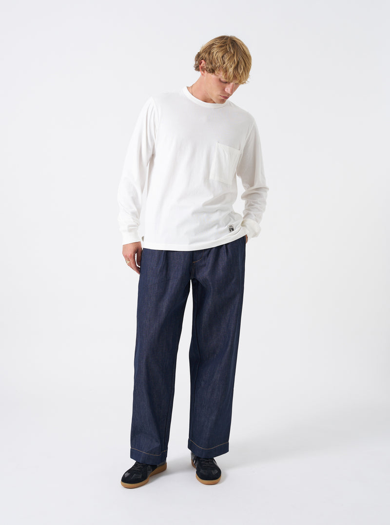 Front shot of the Indigo 13oz Selvedge Denim Duke Pant displayed on a plain white background. Highlights the single pleat front, fixed waistband with belt loops, wide-leg cut with a subtle taper, and dark blue selvedge denim texture.